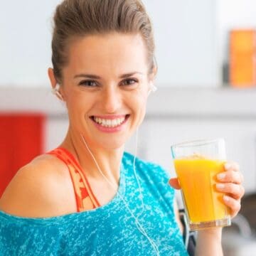 Woman drinking pumpkin juice while smiling into the camera