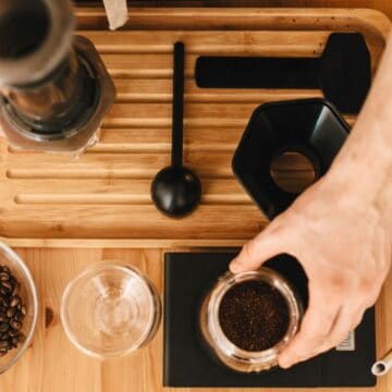 Person brewing coffee using various types of equipment and coffee beans