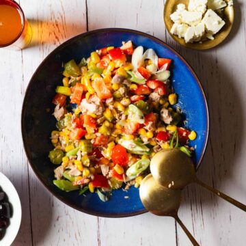 tuna salad in blue bowl with glass of tea