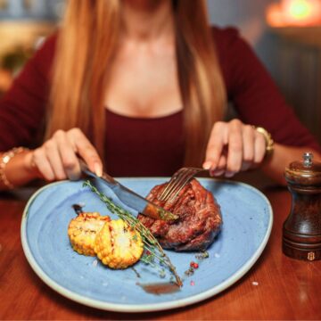 Woman cutting her steak meal