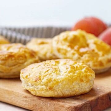 Peach mango pies on a wooden cutting board.