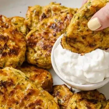 A zucchini bite being dipped into a dipping sauce.