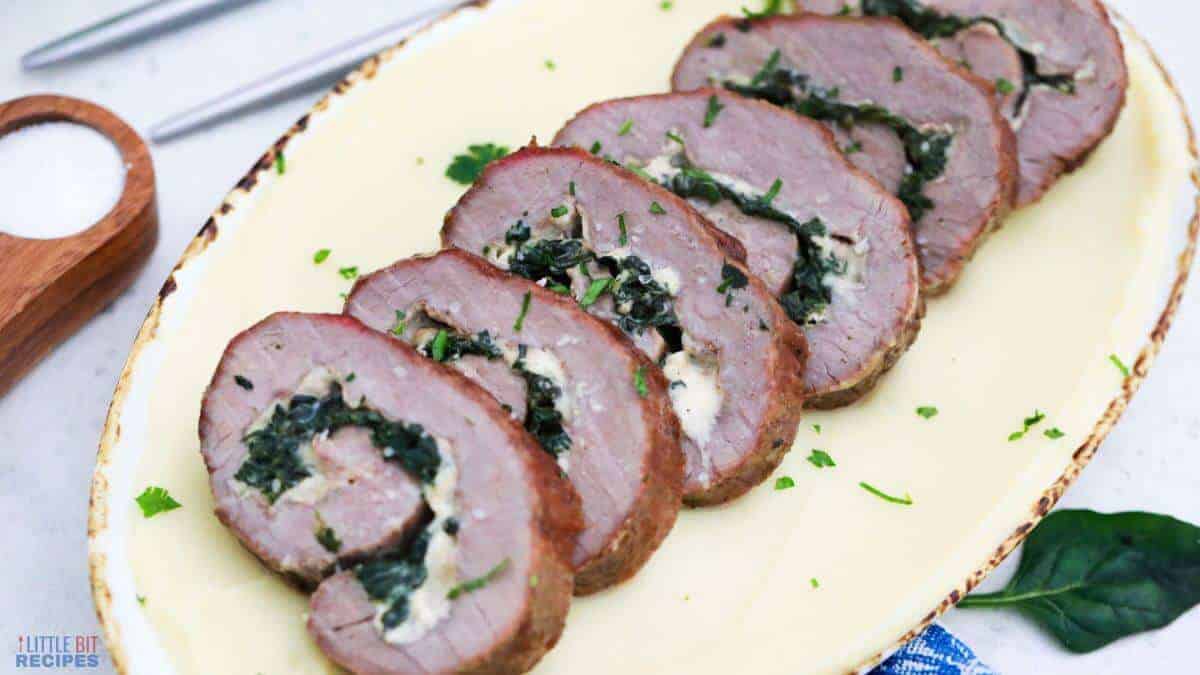 Stuffed steak pinwheels sliced on platter.