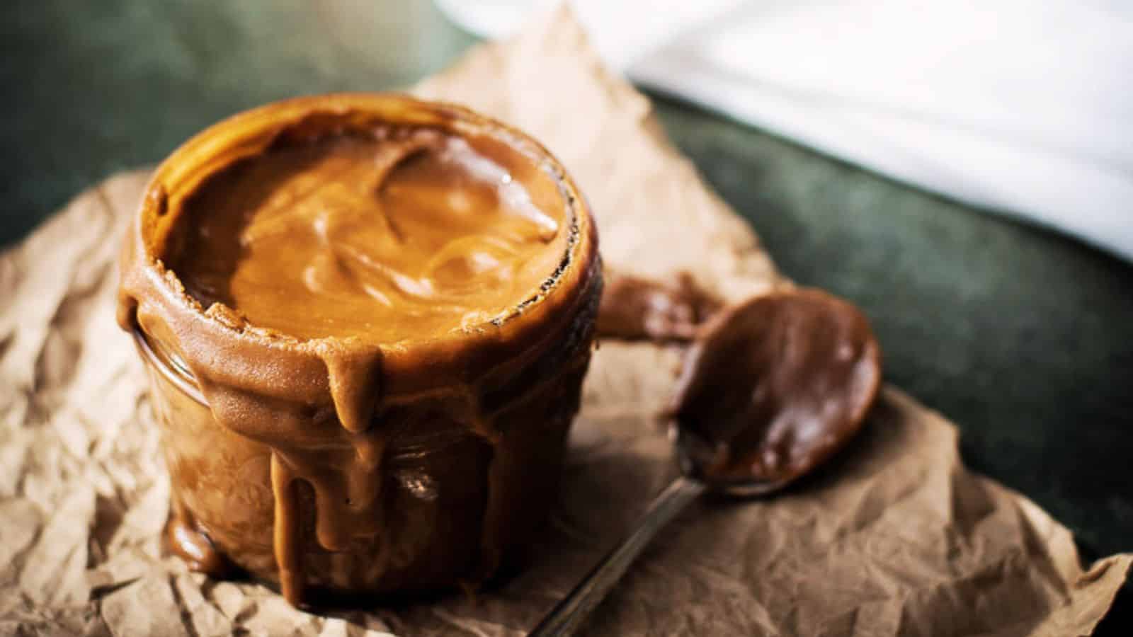 Bourbon butterscotch sauce in a glass jar on brown paper.