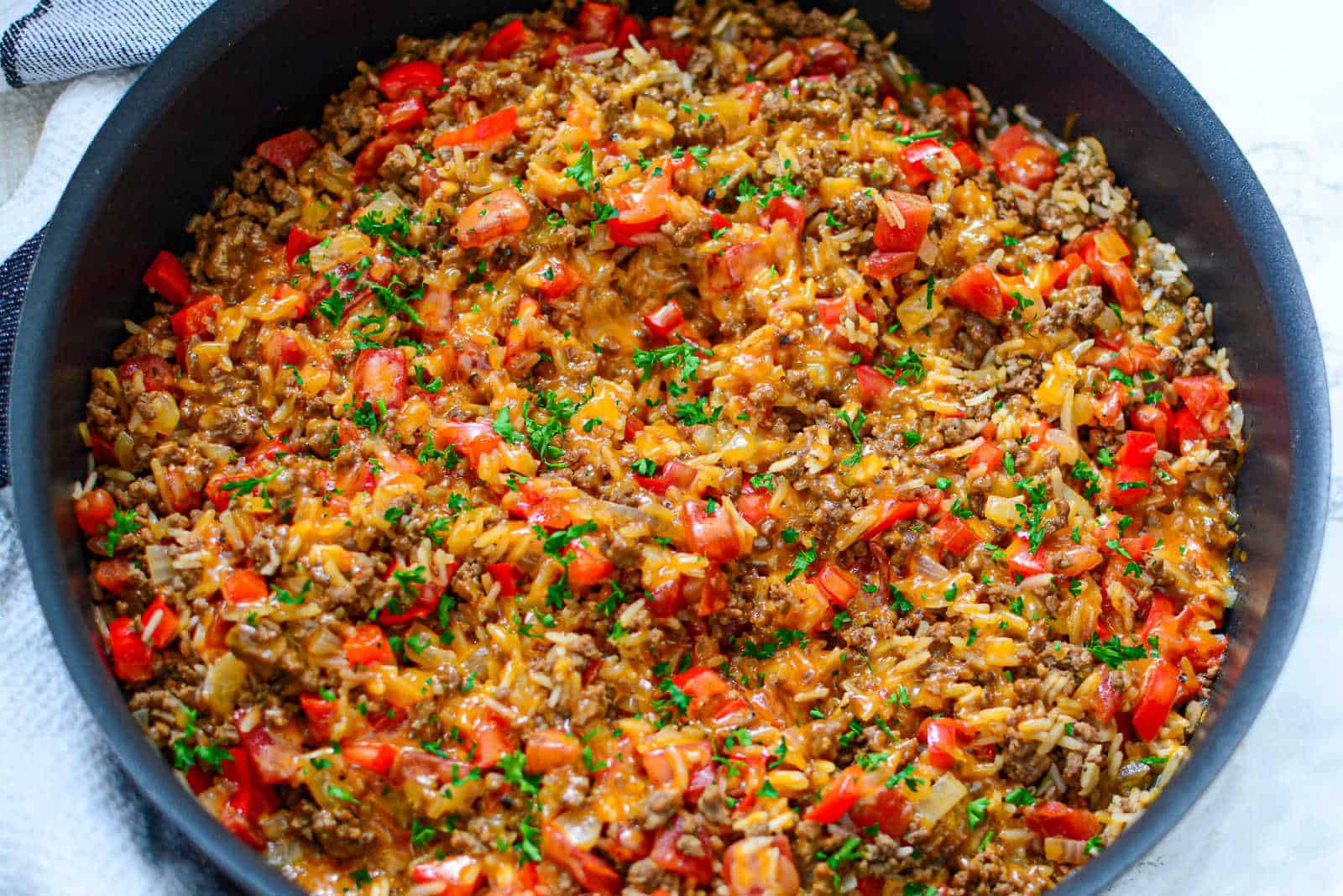 A skillet filled with beef, rice and vegetables.