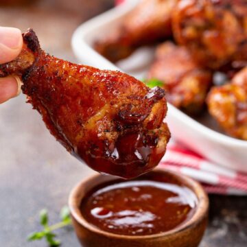 Close-up of a buffalo wing about to be dipped in sauce