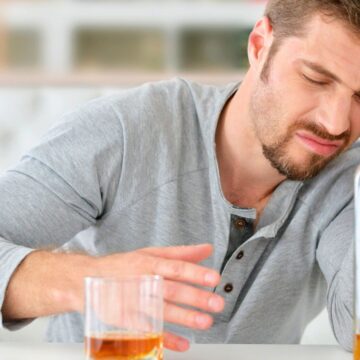 Man shrugging away a glass of alcohol