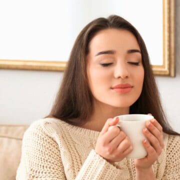 Woman smiling while holding a cup of tea