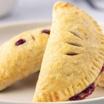 Two cherry handpies on a white plate.
