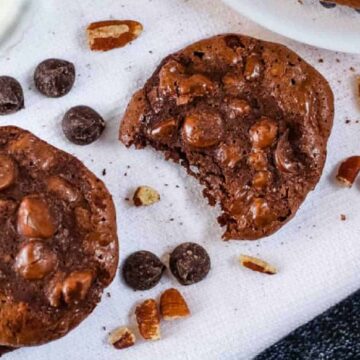 Overhead shot of cookies on a white cloth with a glass of milk.