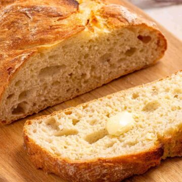 Italian artisan bread sliced on cutting board.