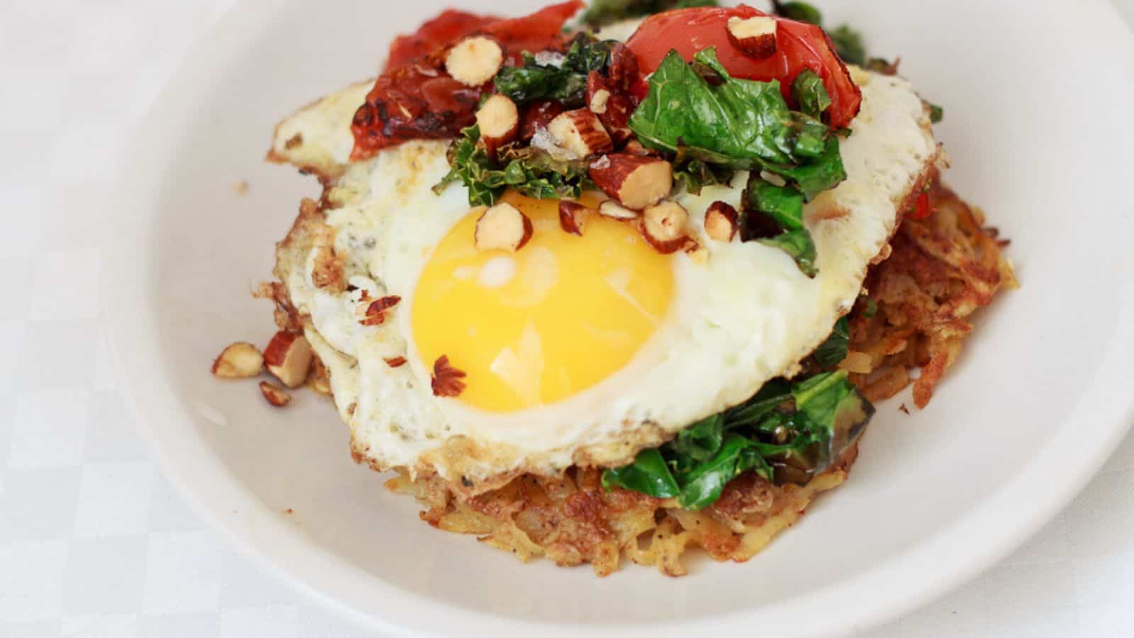 A plate topped with a fried egg and greens.