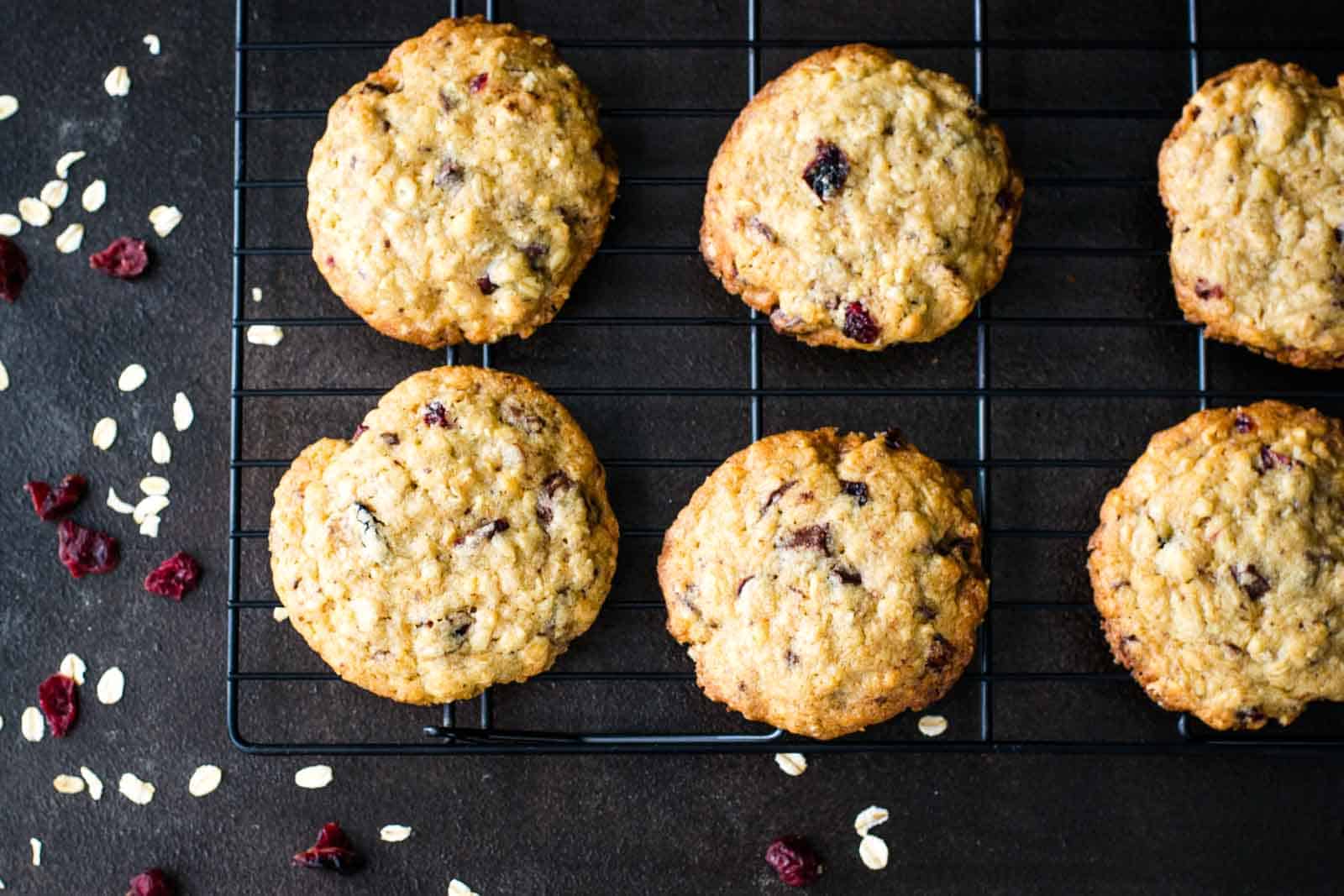 Cookies on a cooling rack on a dark surface.