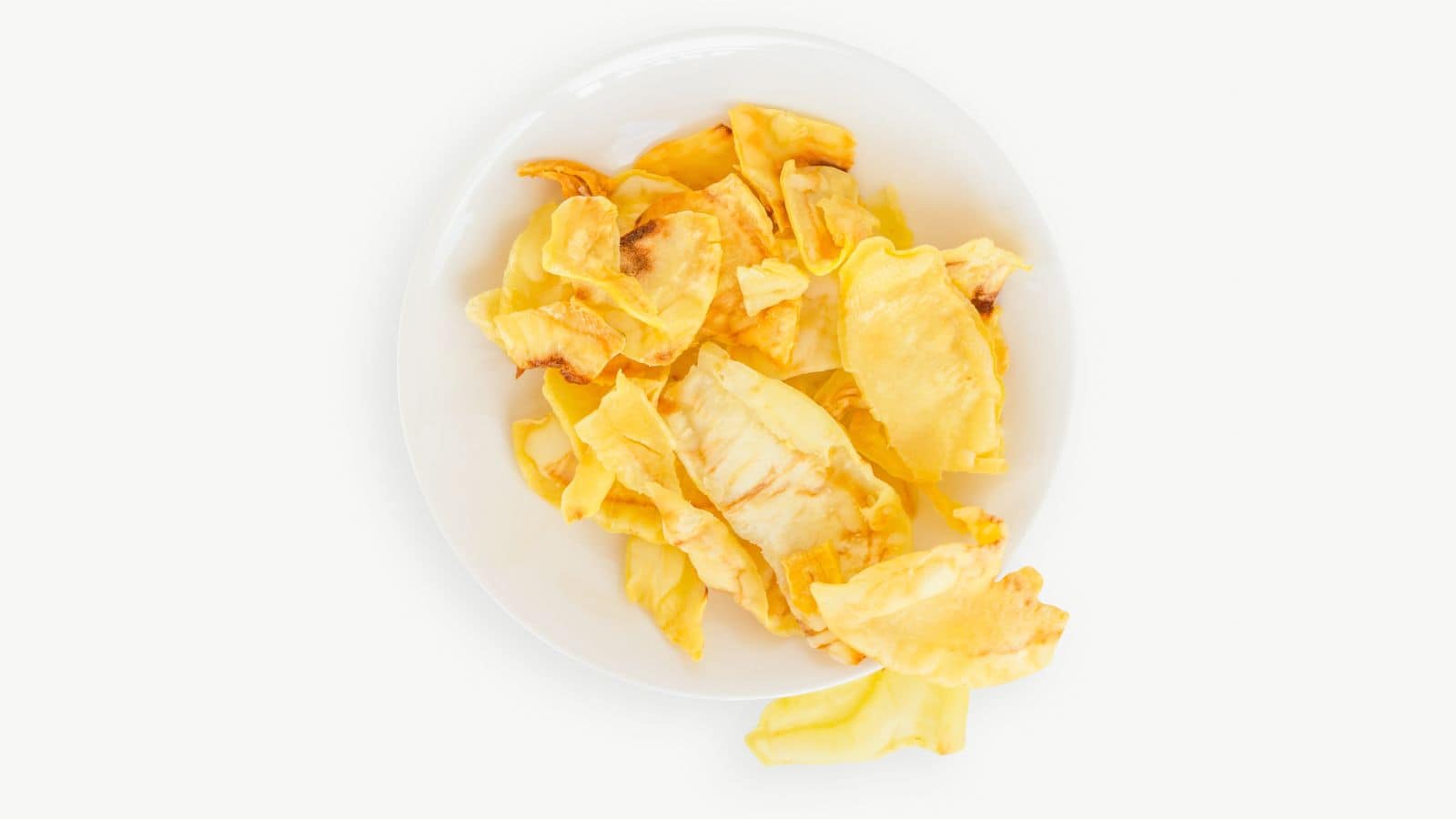 A white plate with a serving of dried jackfruit chips, a delightful addition to the array of international snacks, stands out against a light background.