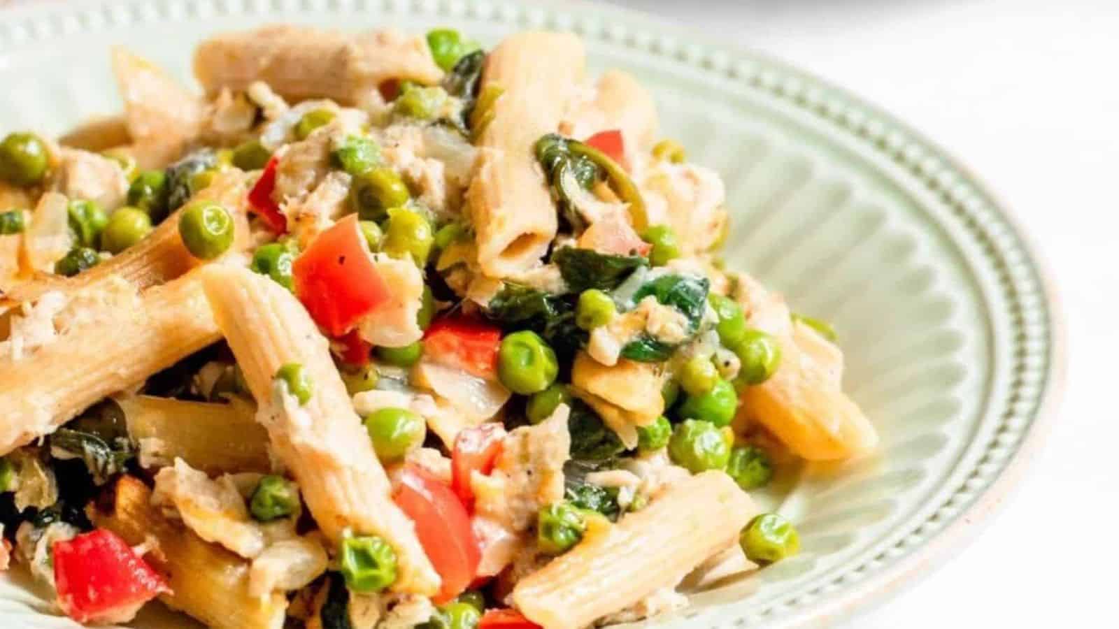 Tuna noodle casserole with vegetables in a shallow light green bowl.