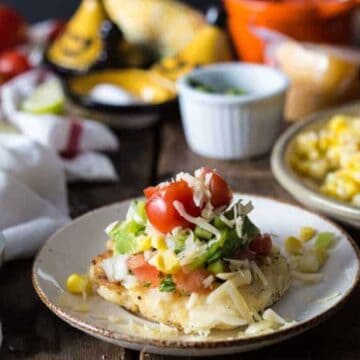 Cheese arepa on a plate with toppings.