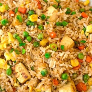 Discover a bowl of fried wonders featuring peas, corn, carrots, scrambled eggs, and tofu cubes. The rice is expertly seasoned and mixed with vibrant vegetables and protein for a colorful presentation—a true taste sensation to try before you die.