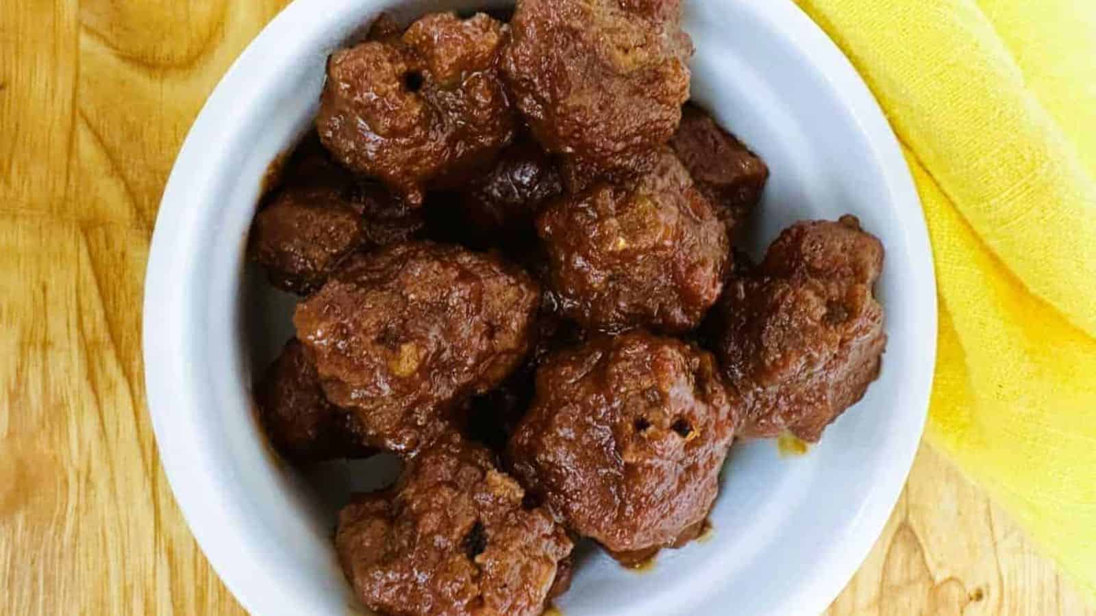 Meatballs in a white bowl on a wooden table.