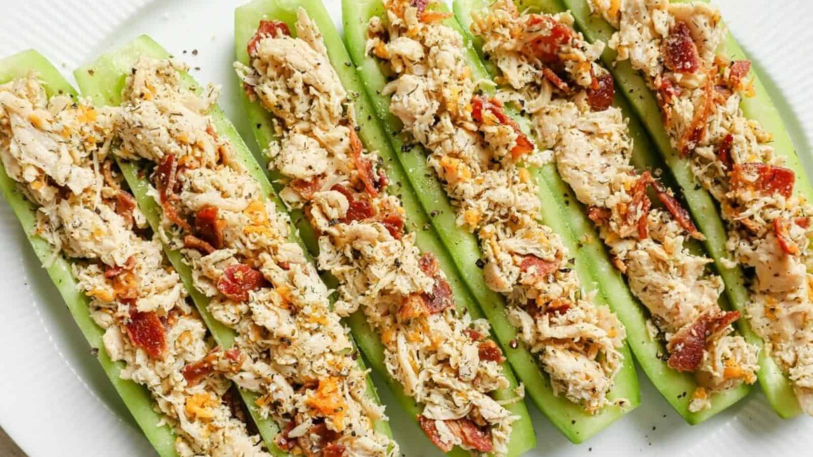 Bacon ranch chicken salad cucumber boats lined up on a plate.