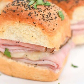 Ham and cheese sliders on a plate.
