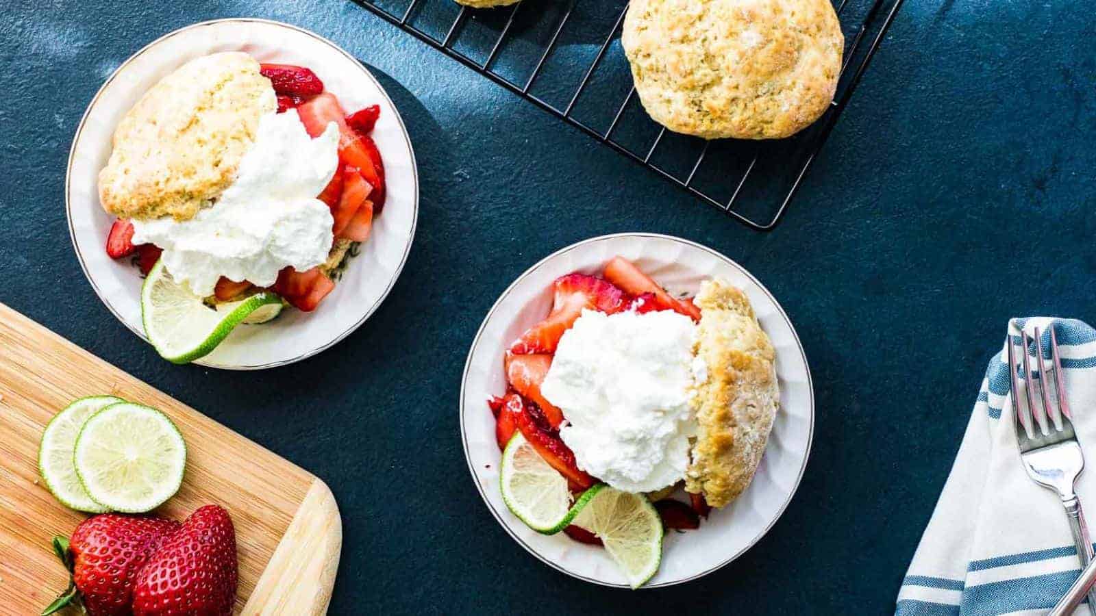 Two servings of strawberry shortcake on a blue background.