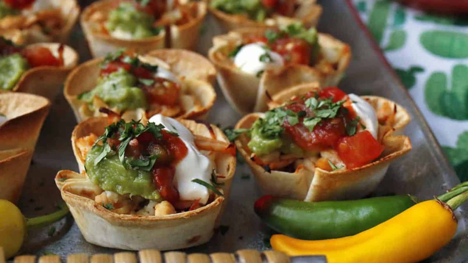 Mini chicken taco cups on a silver tray.