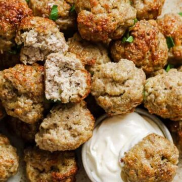 Sausage balls on a plate with a side of dipping sauce.