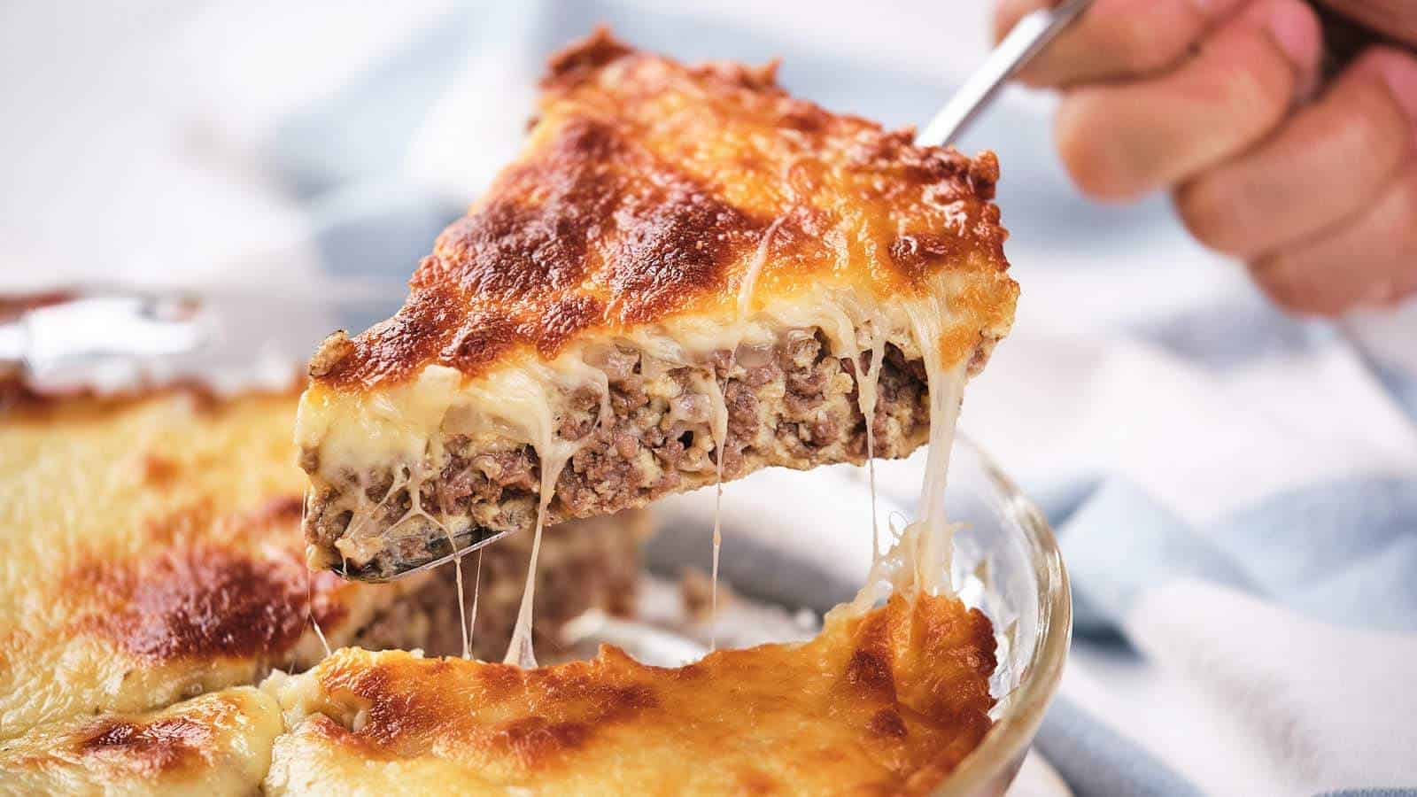 A slice of cheeseburger pie being lifted, showing layers of meat and melted cheese.