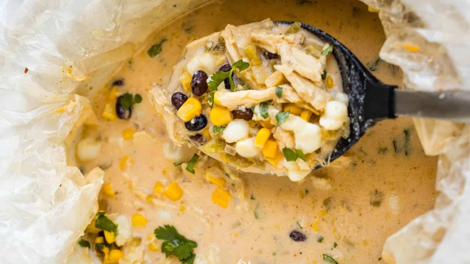 A bowl of mexican chicken chowder with corn and black beans.
