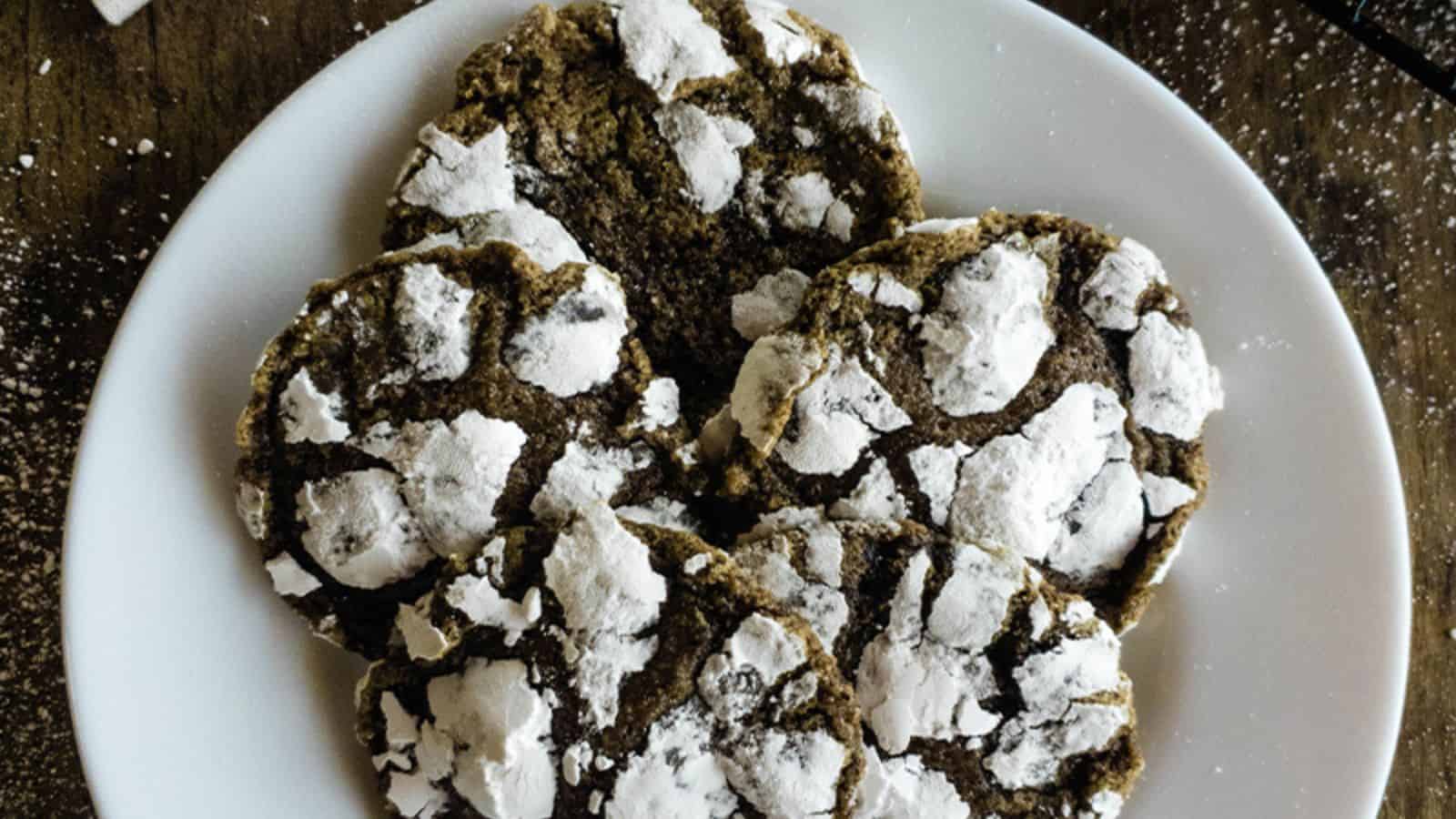 A plate of chai cookies with powdered sugar on it.