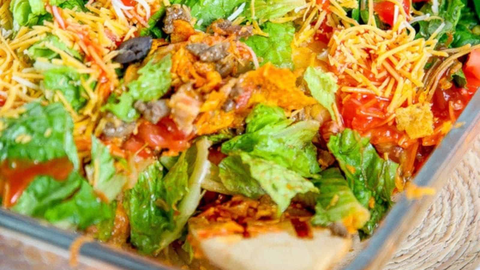 Doritos taco casserole on a plate topped with guacamole and jalapenos.