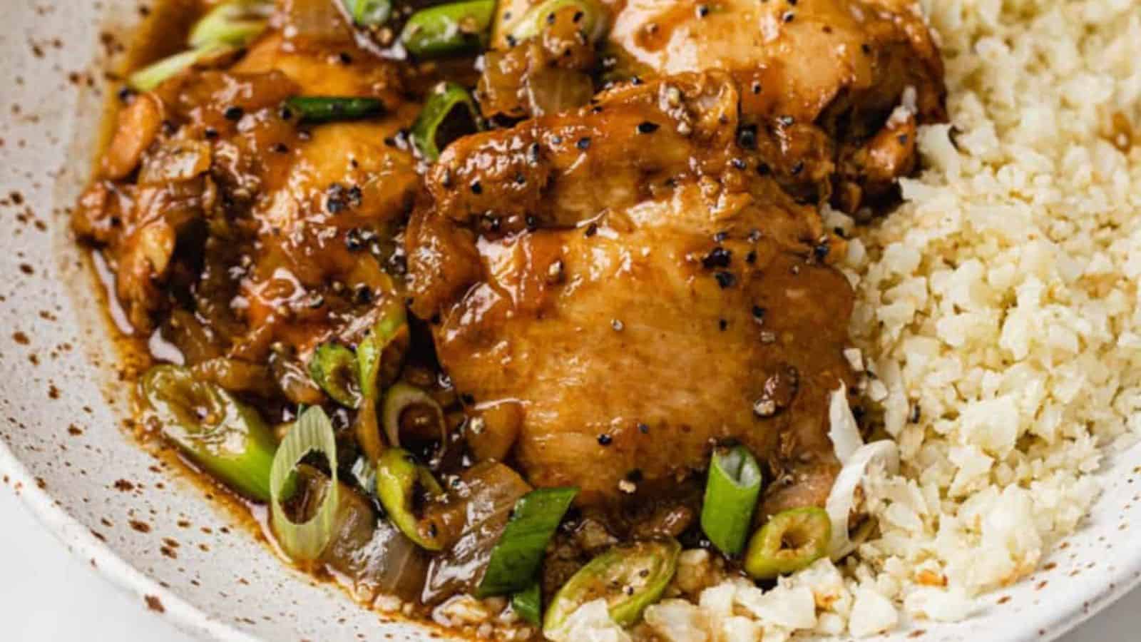 Instant pot chicken adobo in a bowl atop cauliflower rice.