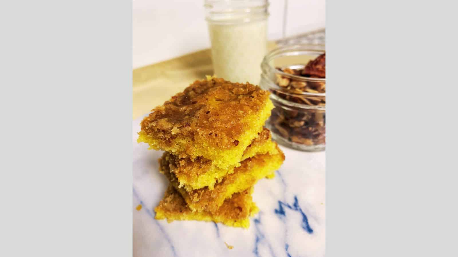Stack of four pecan cake bars on marble board.
