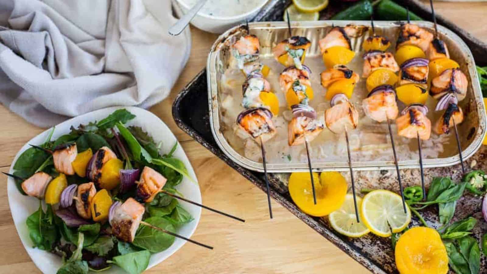 Side view of salmon skewers with more in background.