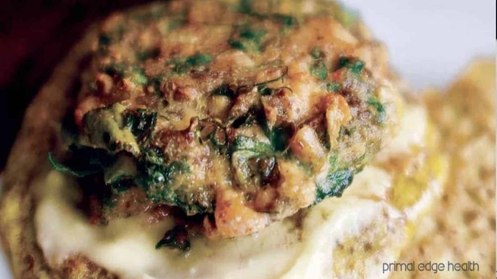 A picture of Keto Spinach Salmon Burgers with cheddar cheese.