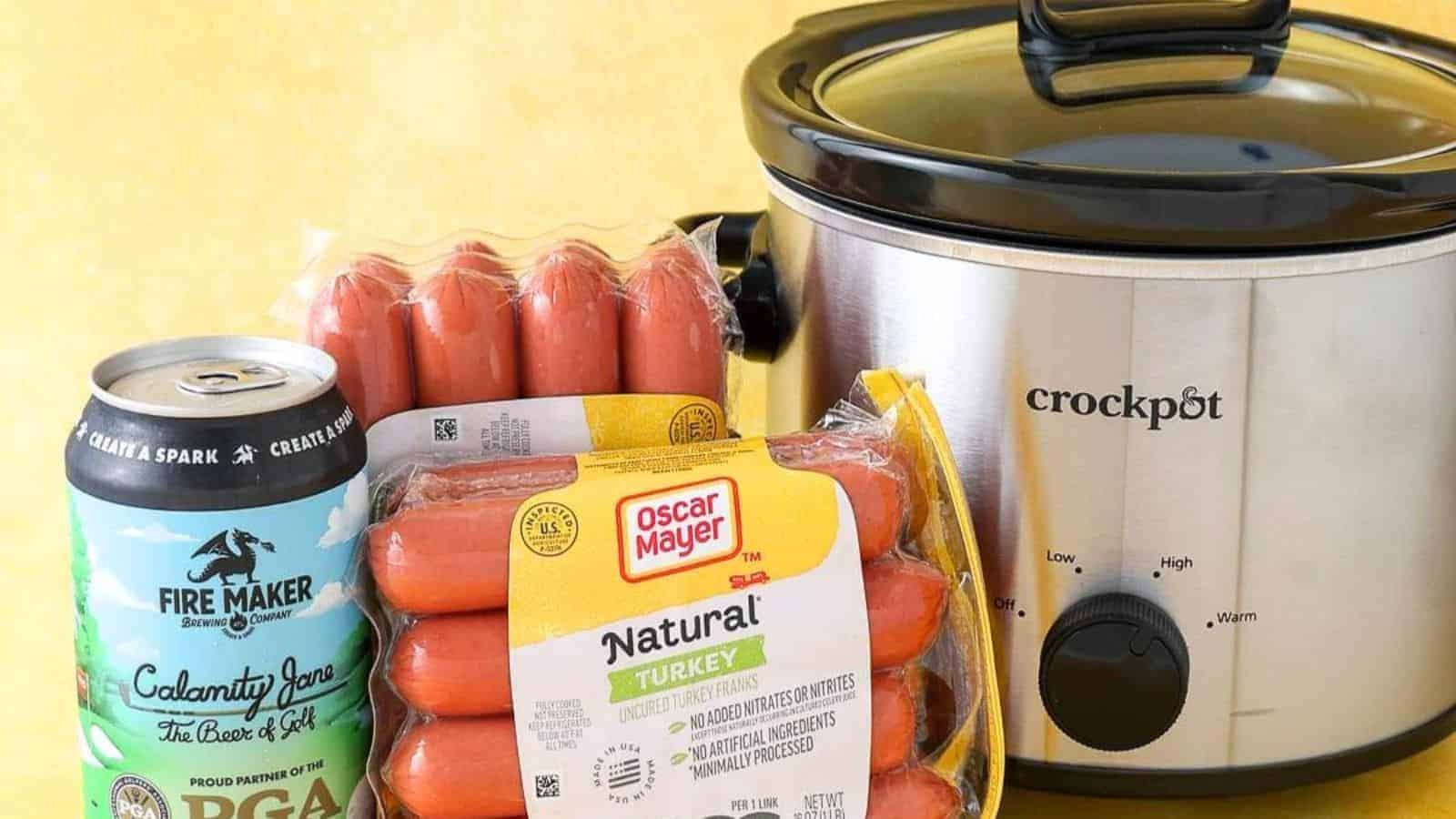 A plate of hot dogs served in a slow cooker with onions and mustard.