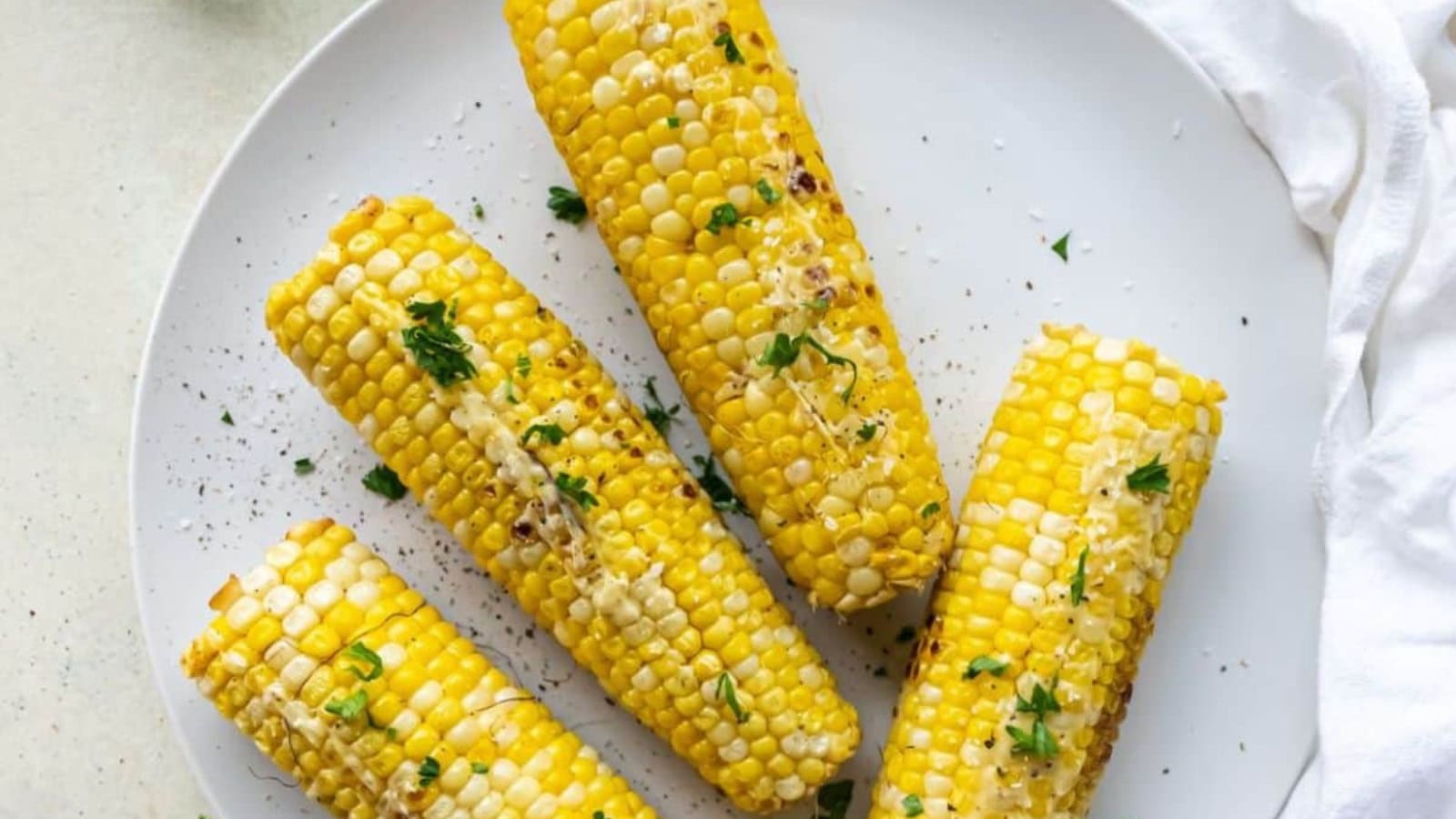 4 corn on the cob topped with butter and parlesy that were cooked on the Blackstone griddle.