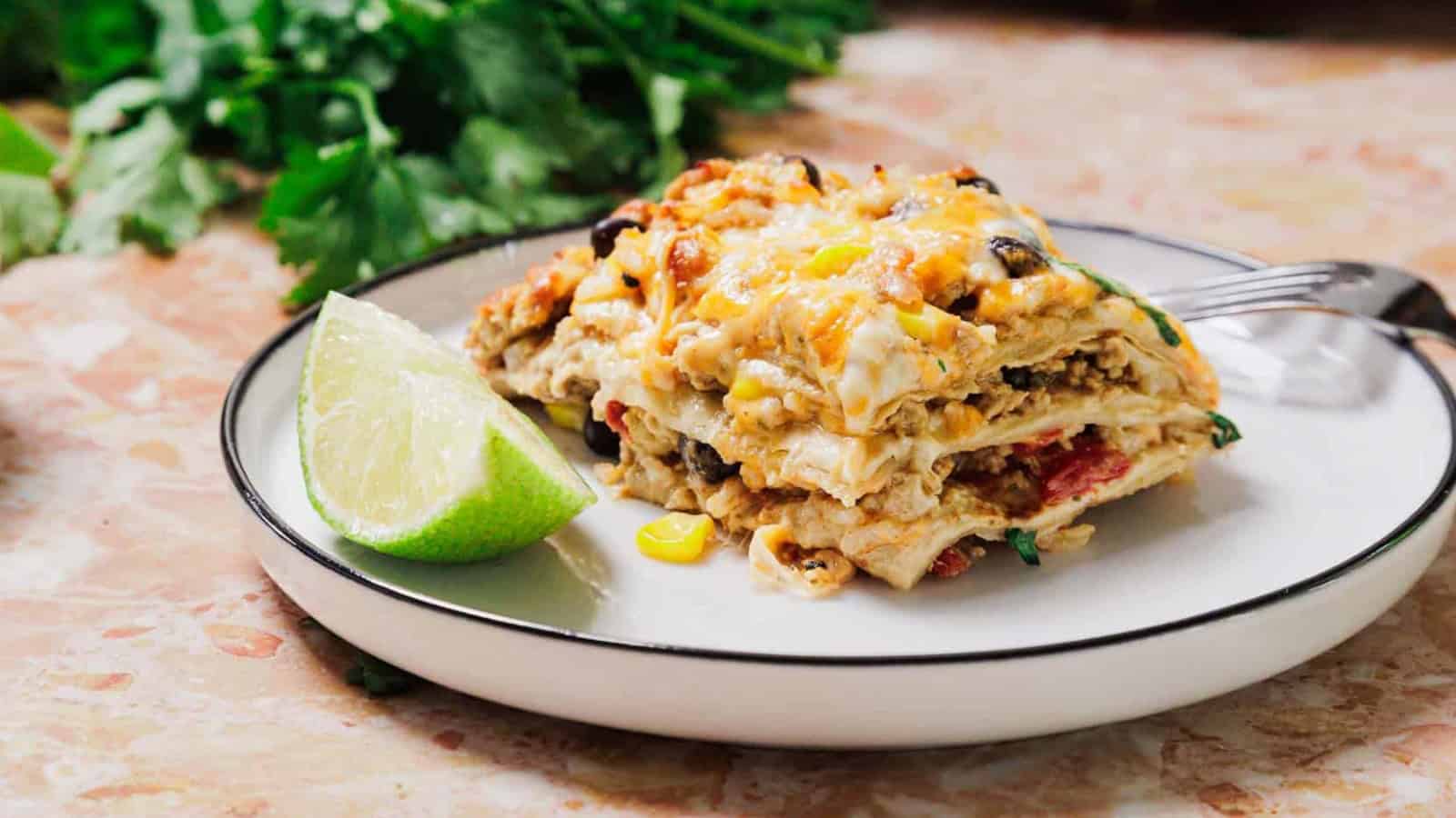 Baked egg casserole with cherry tomatoes, avocado slices, and fresh herbs in a blue cast iron dish.