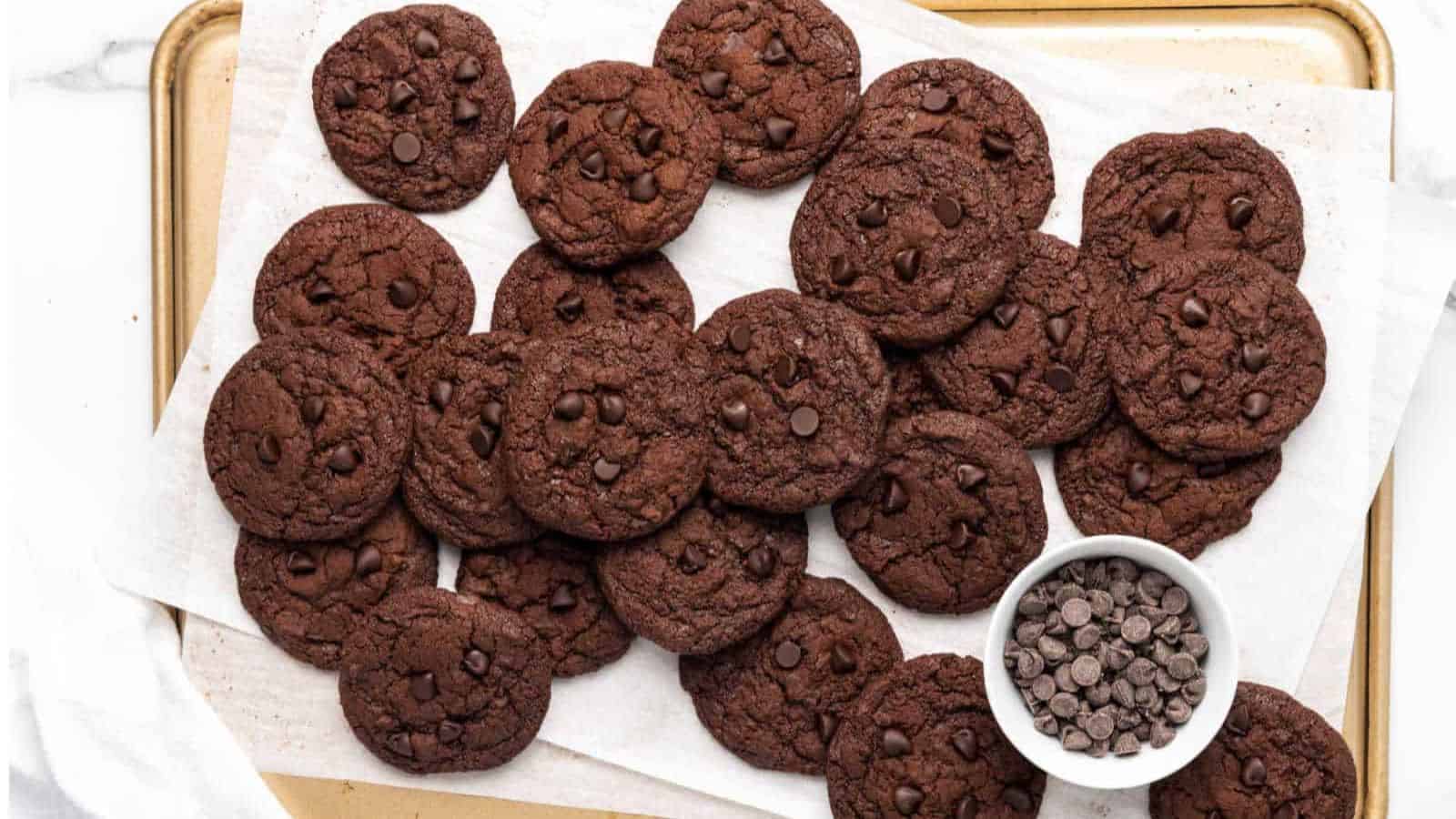 Chocolate chocolate cookies on parchment paper on a cookie sheet.