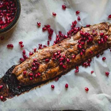 Pomegranate-glazed salmon on a sheet of parchment paper.
