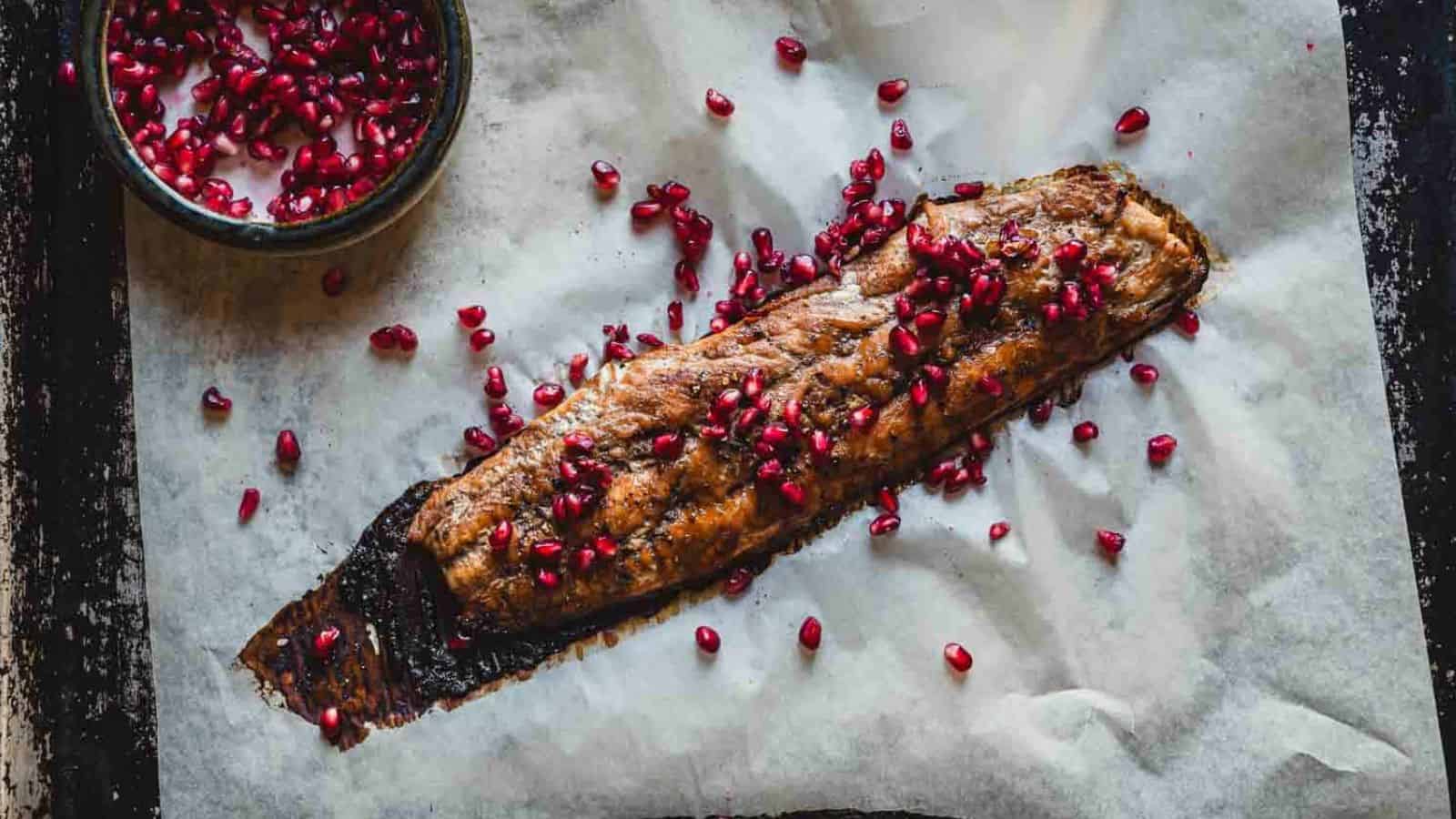 Pomegranate-glazed salmon on a sheet of parchment paper.