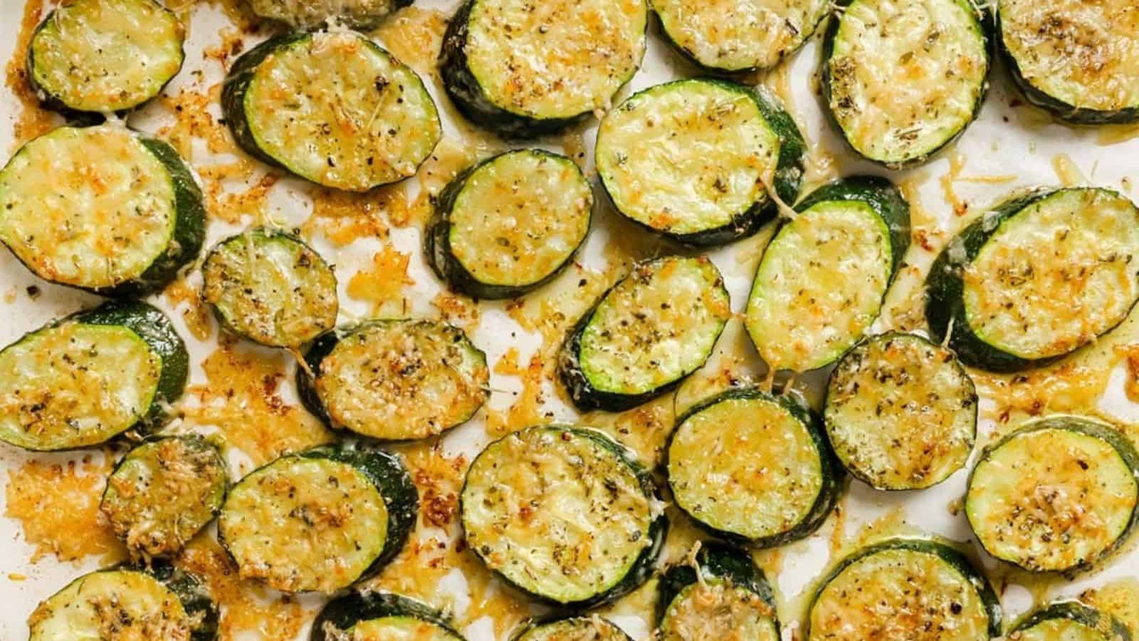 Baked sliced zucchini with parmesan on a white plate.