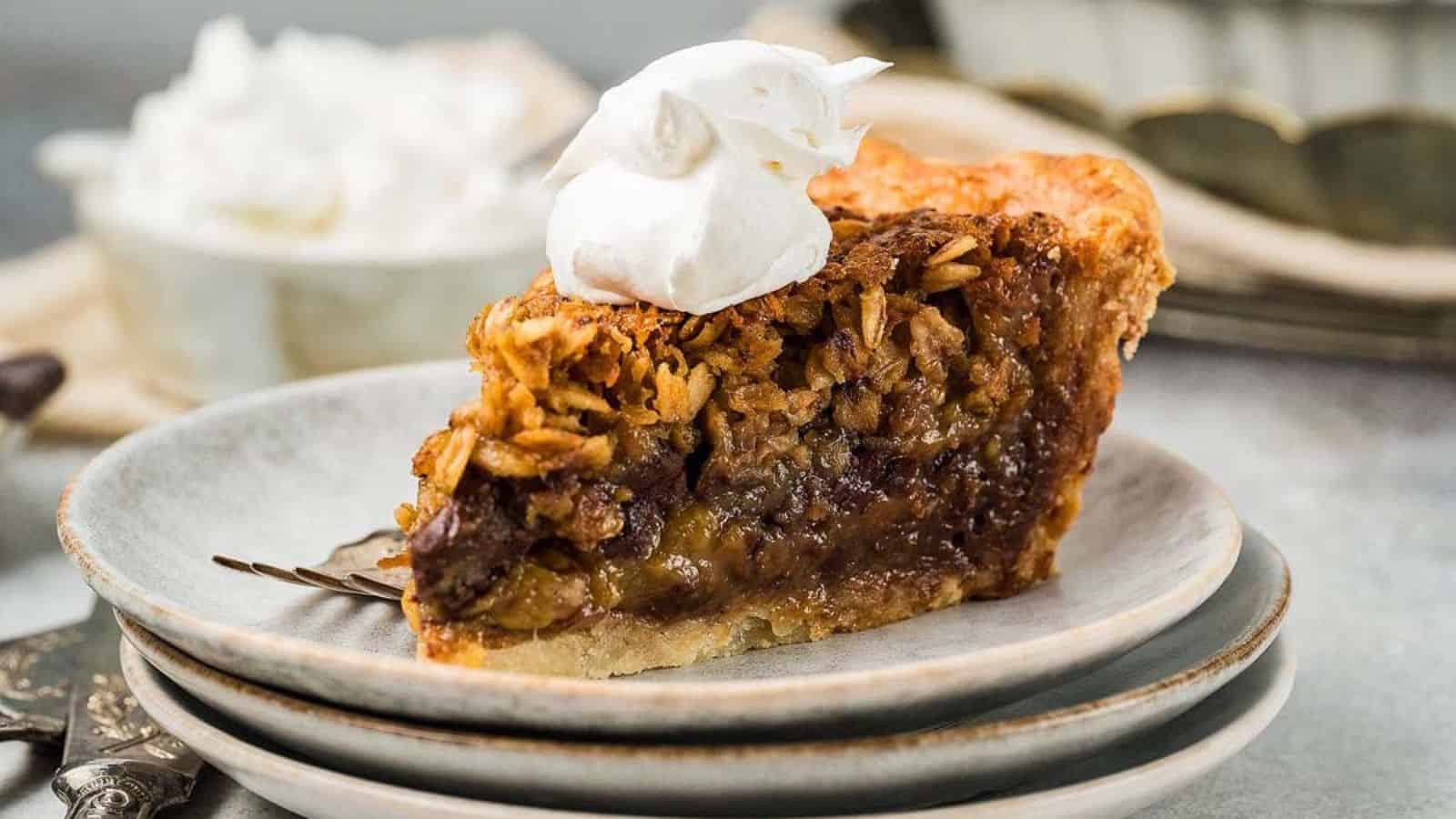 Slice of Black Bottom Oatmeal Pie topped with whipped cream on a stack of plates with a fork beside it.