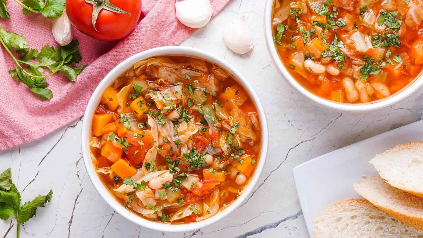 An overhead image of two cabbage soups in a white serving bowl.