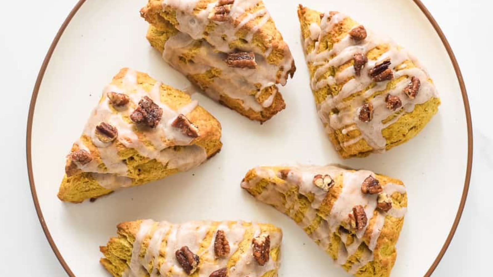 Glazed scones on a baking sheet.
