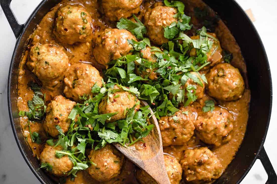 Coconut curry Thai turkey meatballs on top of cauliflower rice in a bowl.