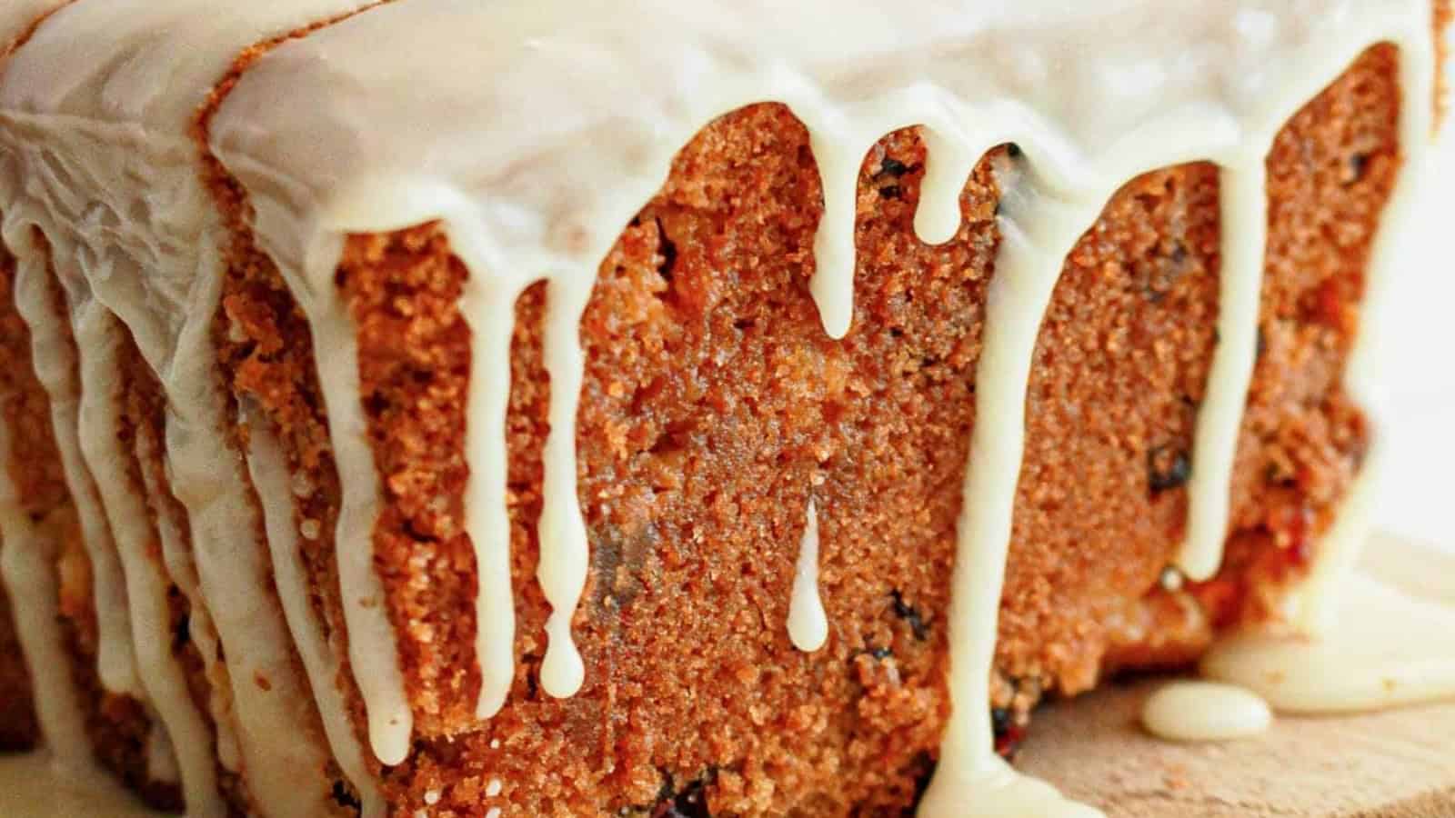Close-up of a loaf cake with white icing dripping down the sides.