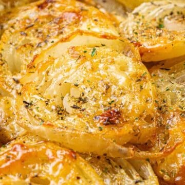 Close-up of roasted onion slices topped with herbs and golden, caramelized edges—a delicious addition to your lineup of classic side dishes.