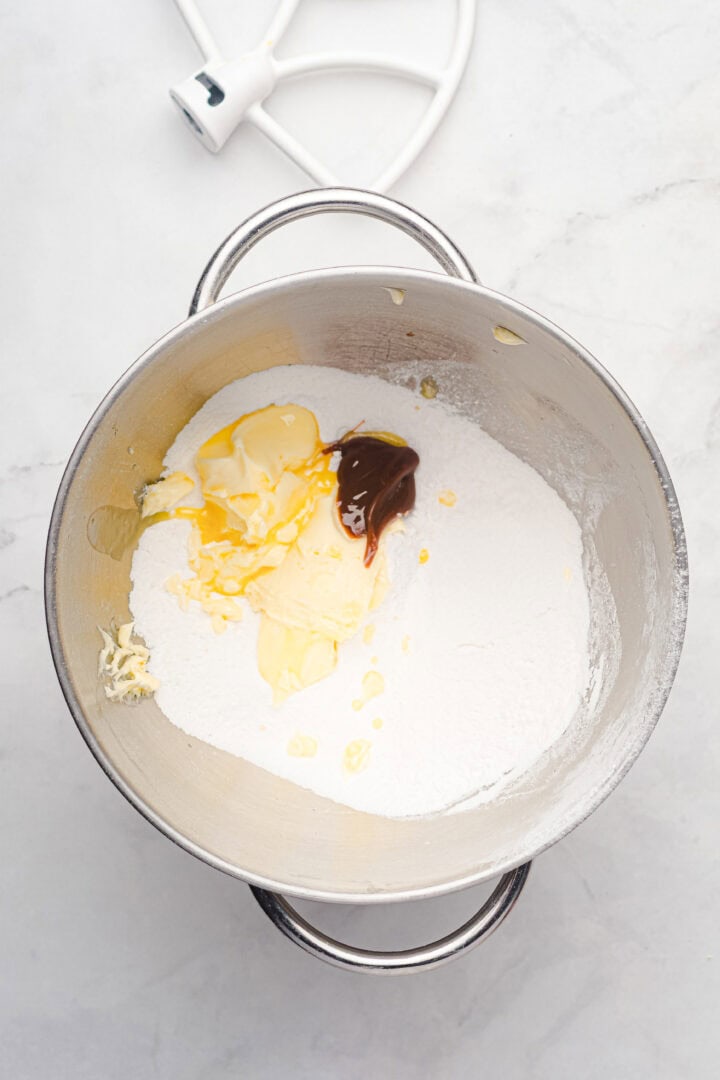 A mixing bowl with flour, butter, vanilla extract, and an egg yolk—everything you need to start baking delicious gingerbread muffins.