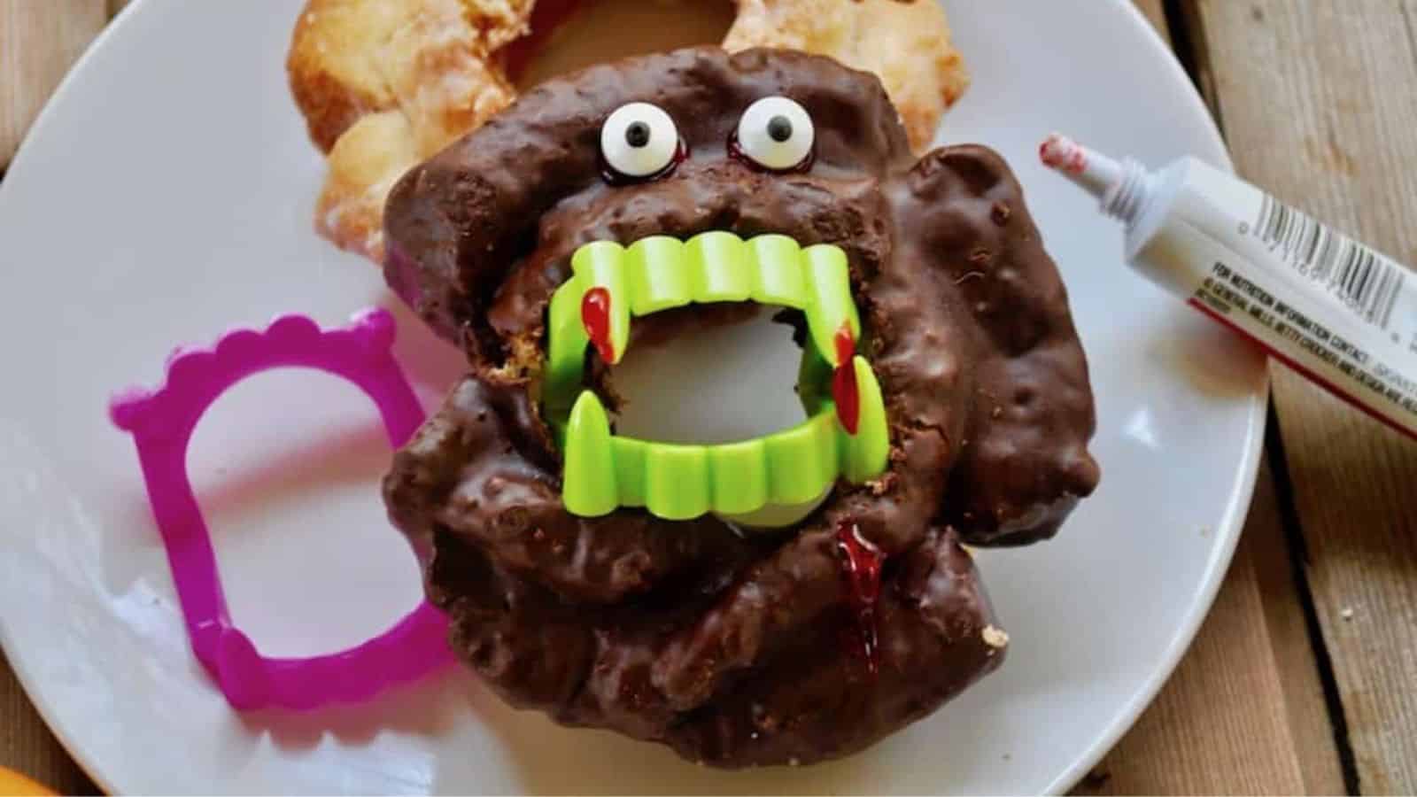 Chocolate doughnut with bloody vampire teeth.